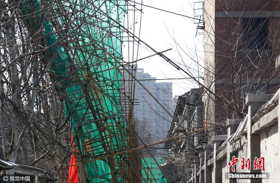 郑州前进路街头20米高 数十吨重钢铁脚手架突遭大风袭击悬在马路半空中