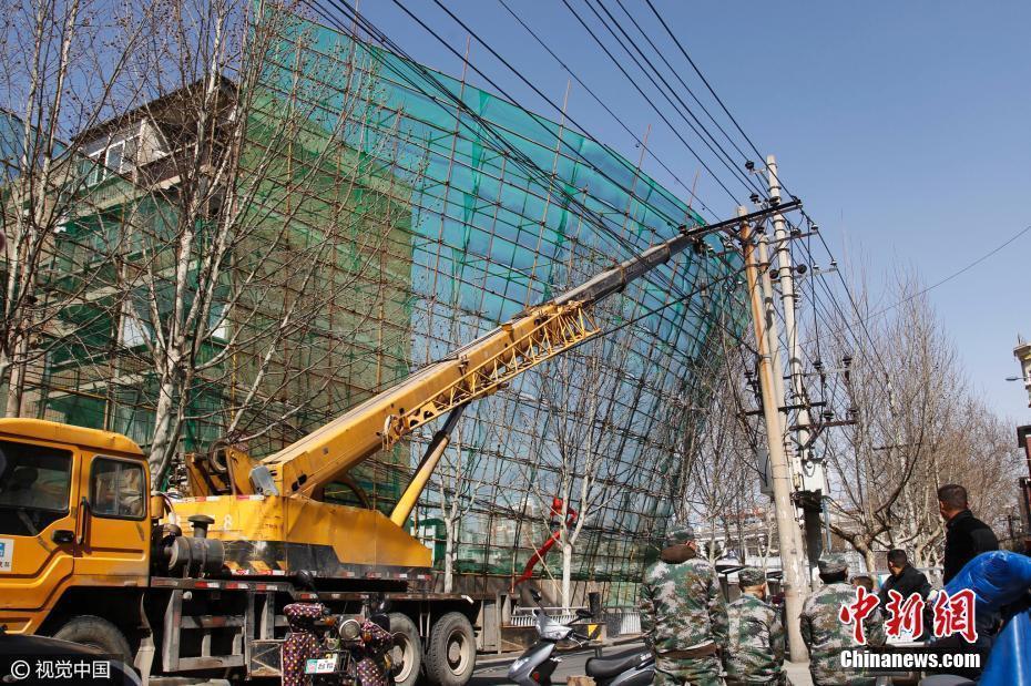 郑州前进路街头20米高 数十吨重钢铁脚手架突遭大风袭击悬在马路半空中